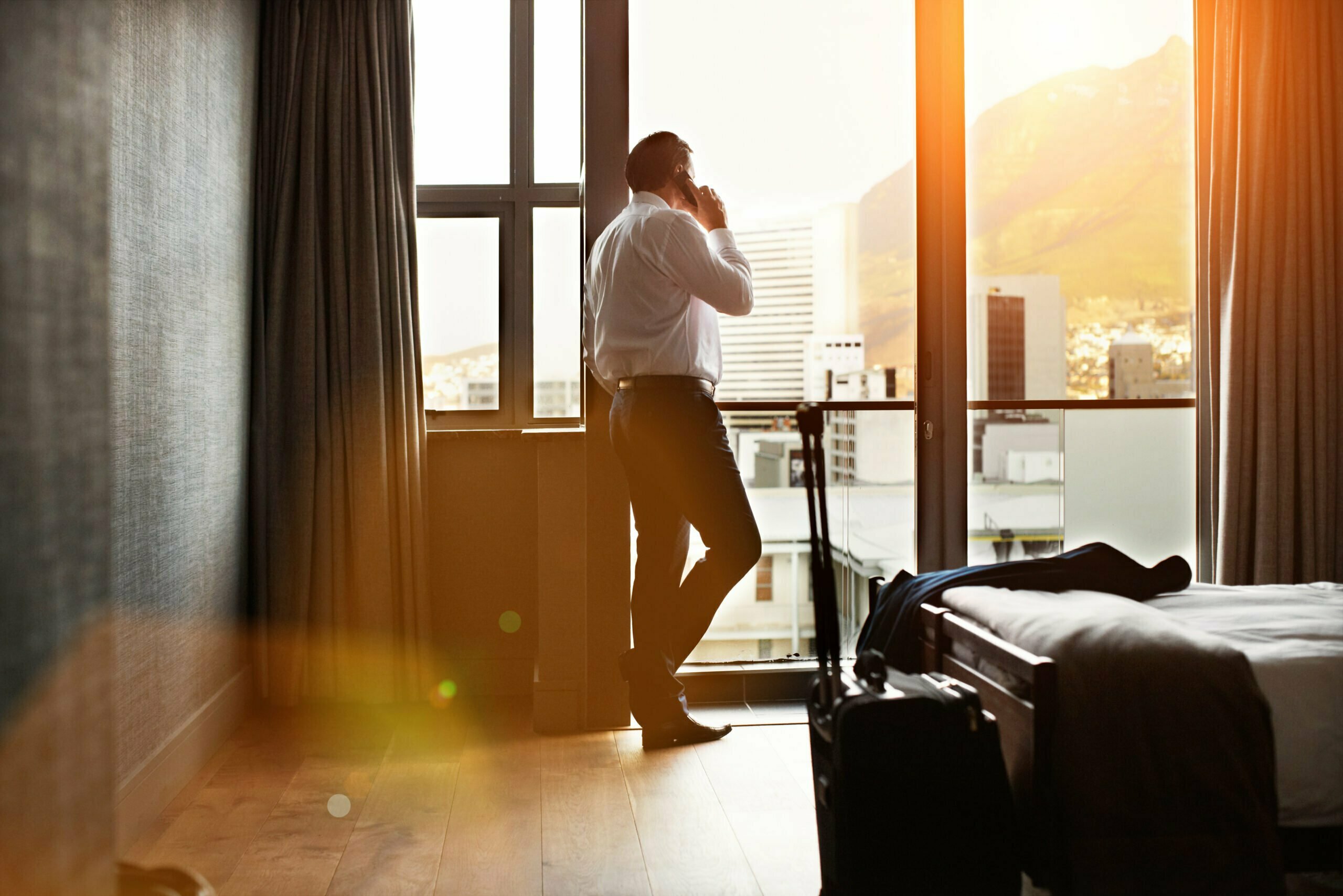 Corporate traveller in their hotel room on the phone with a dedicated agent